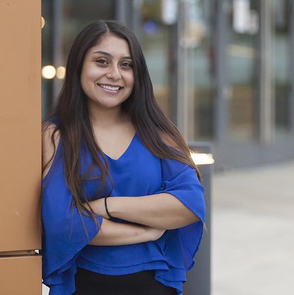 student stands outside ASC building